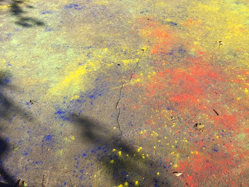 Splotches of color powder on the sidewalk